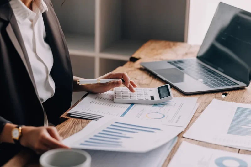 Marketingový tým u stolu plánuje kampaň nad notebooky a grafy