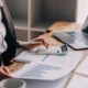 Marketingový tým u stolu plánuje kampaň nad notebooky a grafy